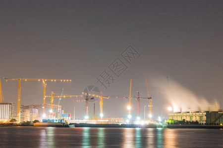发电厂和建筑起重机在河边的夜晚场景日落石化图片