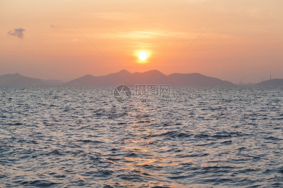 清晨日出山峰和海面的一幕云日落阳光图片