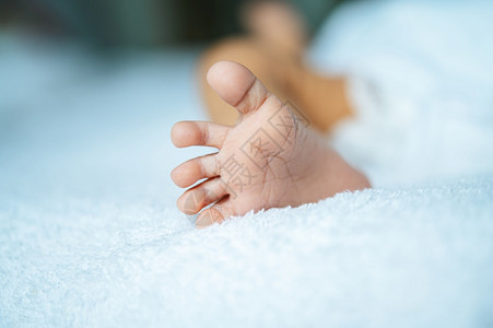 美丽的人类脚趾白毯子上新生婴儿脚图片