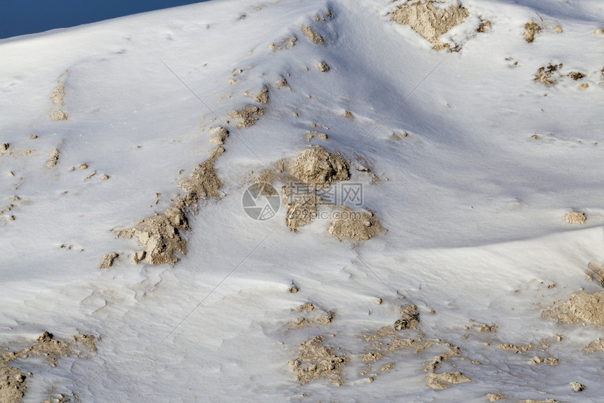 在建筑工地造的一堆黄色沙子暴风雪和降后被白覆盖紧闭了一堆黄色沙子车辆投掷铲图片