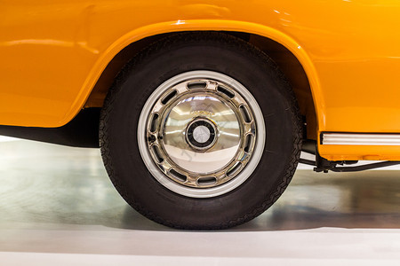 种族磁盘橙色汽车上的黑旧轮子和德国工作室灯光的波兰车轮边抛光图片