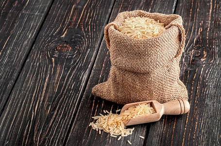 亚洲营养人袋长米和勺子放在木底背面上袋大米和勺子摊图片