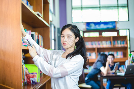 在书架上搜寻书籍的女学生图片