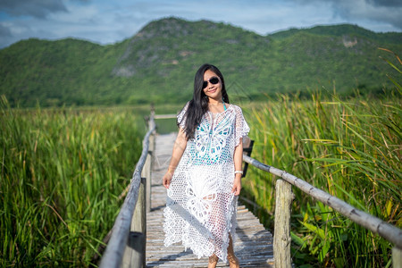 年轻女站在木桥上以自然背景为本放松亚洲人热带图片