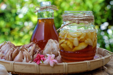 有机的食物关心来自然草药蜂蜜中浸泡的大蒜一种用于皮肤护理保健的草药三罐绿色本底图片
