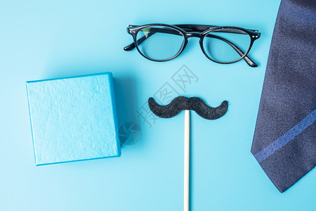 黑色的十一月最小黑胡子礼物眼镜和领带蓝底背景父亲节快乐和国际门徒节概念生日图片