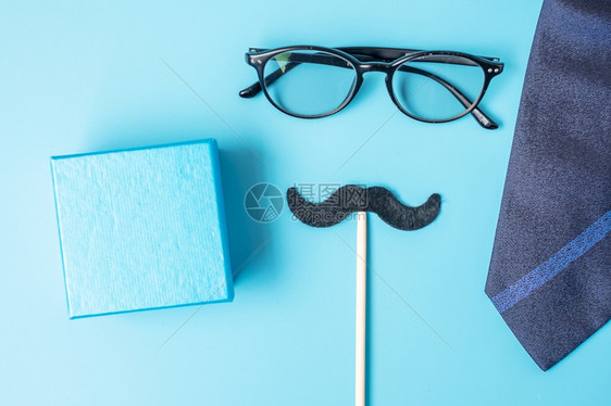 黑色的十一月最小黑胡子礼物眼镜和领带蓝底背景父亲节快乐和国际门徒节概念生日图片