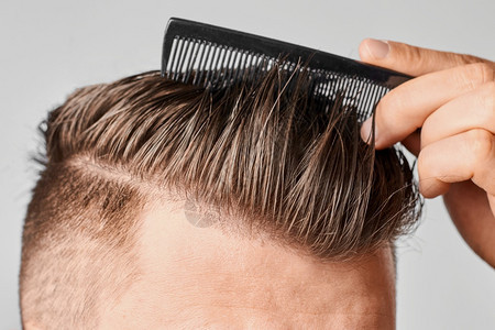 损失男人用塑料梳子理干净的头发在家做型脱或头皮屑的概念男人用塑料梳子理干净的头发在家做掉或皮屑的概念客户肖像图片