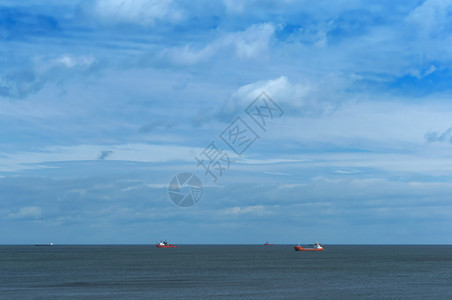 生产原油海上石钻探地平线上海的船只平静而多云的天空地平线上的海船只石油钻井平静而多云的天空工人图片