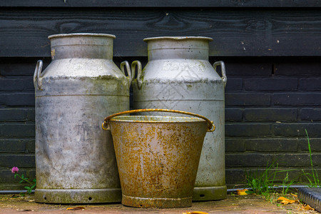 一种目的旧农用设备金属奶罐和旧生锈桶农业背景图片