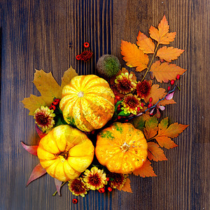 落下乡村万圣节木质背景上橙黄和红颜色叶白花朵和南瓜的秋幕背景图片