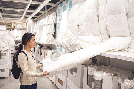 亚洲白色的女顾客在超市商场店里选择床单和毯子她正在检查床垫以支付费用店铺图片