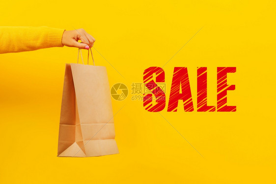 关于黄色背景折扣和销售概念的手头纸袋式购物奢华顾客复制图片