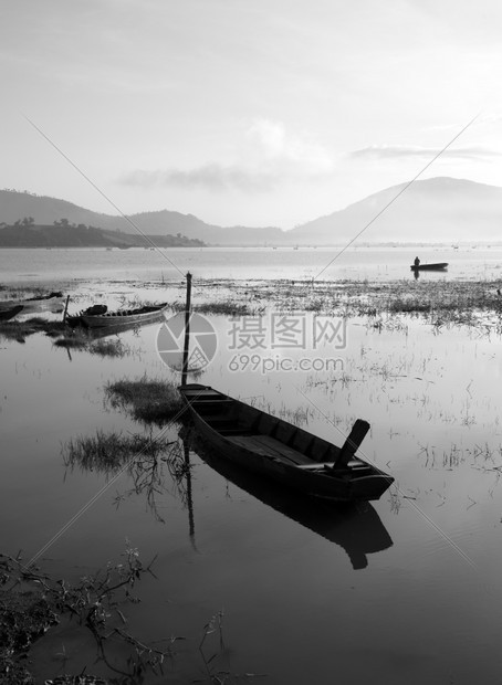 农村冷清早晨宁静的湖以黑黄白色音调渔民在那里生活船只在地表水上反射图片