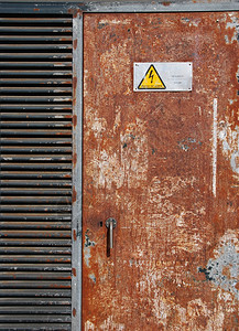 工业的垃圾摇滚禁止生锈金属门上的高电压标志图片