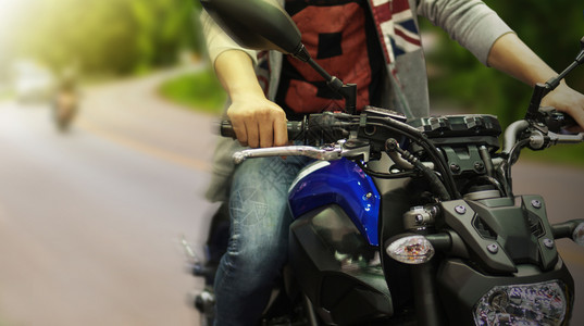 驾驶摩托车的高功率手紧贴上运输人们哈雷背景图片