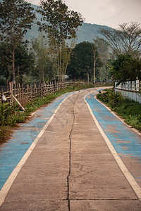 农村的混凝土道路在山谷里有蓝色自行车路段可骑自行车沥青驾驶图片