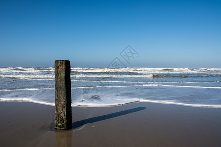 风暴天气极荷兰海滩上的木杆图片