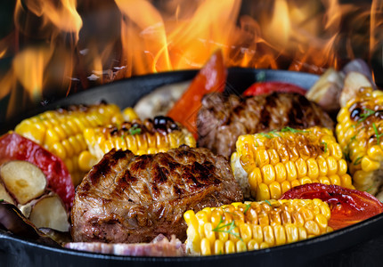 炸肉和玉米有蔬菜在煎锅里烧火健康天然食品的概念炒肉和玉米与蔬菜在煎锅里烧火平底小牛肉迷迭香图片