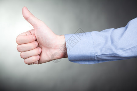 象征信号打手势身穿衬衣的人在审批时用拇指举牌图片