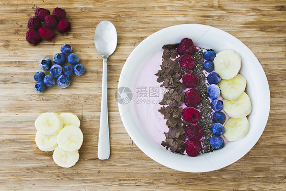 乡村木制的白色一个滑水碗配有新鲜果子香蕉草种子和巧克力用于健康素食和早餐图片