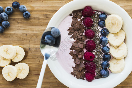 一个滑水碗配有新鲜果子香蕉草种子和巧克力用于健康素食和早餐水果白色的乡村图片