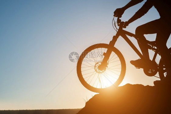 轮廓户外自然日落时骑着山上摩托车的男人休眠图片