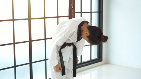 强的冲床手空和服鞠躬的亚洲女人黑色图片