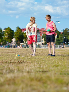 友谊两个女人在公园里玩花石在下午的阳光城市背景上爱幸福图片