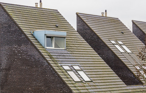 现代荷兰三角形房屋的顶新设计建筑有屋顶瓦砖的宿舍窗户荷兰一个小村庄的住宅等这些房子是荷兰的一个小村庄家典型的新背景图片