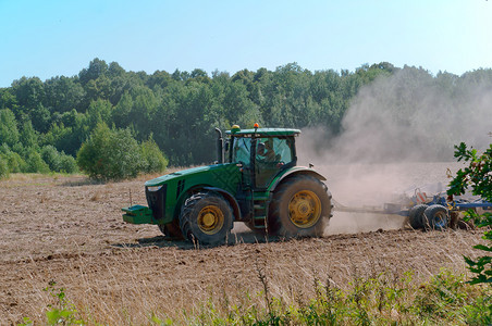犁车辆耕地的拖拉机在田间工作的农业机械在田间工作的农业机械在耕地的拖拉机图片