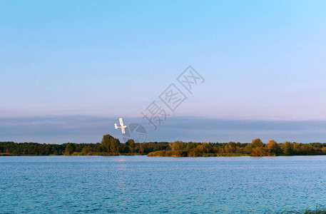高的技术秋天白色一架飞机越湖面小型机在天空中白色一架飞机越过湖面图片