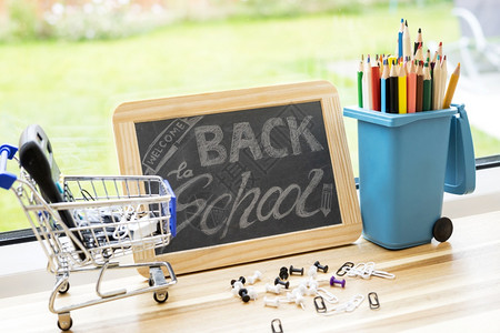 颜色木制的后退回到学校背景有黑板铅笔在垃圾桶玩具上计算器在购物车上和推纸在木头图片