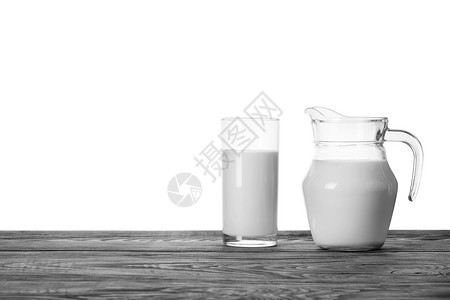 一块木制桌上的果汁和一杯牛奶在白色背景上隔绝的木制桌子上一个木制桌的果汁和一杯牛奶寒冷的木头图片