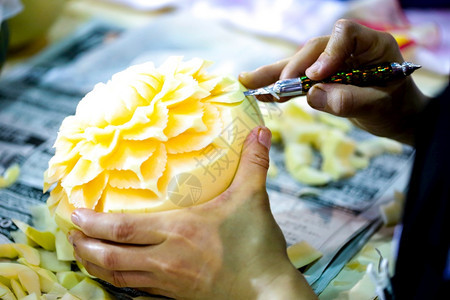 一名工作者在为瓜果雕刻花朵图片