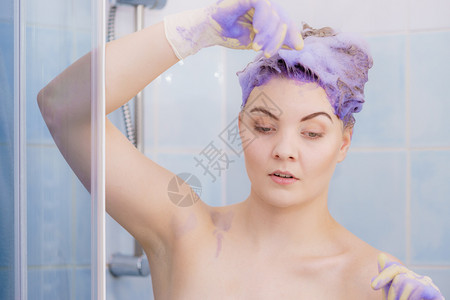 等待在头发上染色洗水的女人有紫色洗涤产品的女人在家调色金发女人在头上涂调色剂洗水干净的手套淋浴图片