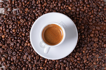 咖啡在豆背景中心端着咖啡的白杯子饮料木头种图片