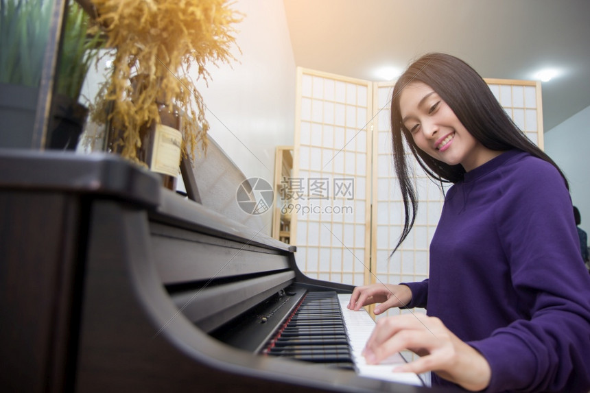 旋律经典的艺术美丽亚洲女在弹钢琴时有选择地关注面部图片