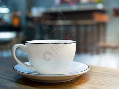 木制桌上的热咖啡白杯馆或店阳光模糊背景的浓咖啡木头抽烟散景图片