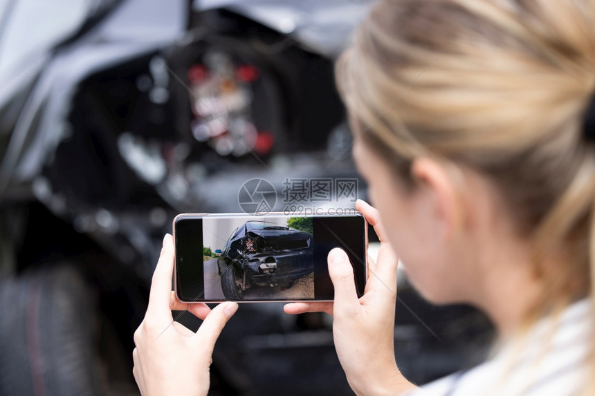 二十多岁破坏凹陷的女驾驶员在事故发生后为移动电话保险索赔拍摄受损汽车照片的女司机图片