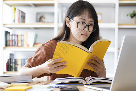 在电脑上学习的戴眼镜女孩图片