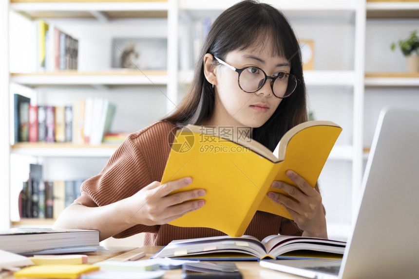 在电脑上学习的戴眼镜女孩图片