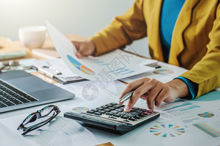 计算从事金融和会计工作的商业妇女对办公室财政预算进行分析在办公室财务预算股票笔记本电脑图片