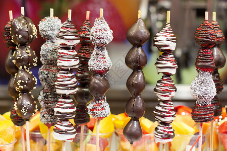 巧克力在巴塞罗那市集上浸泡的草莓涂层成熟浆果图片