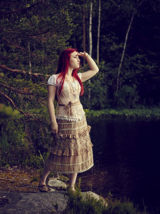 森林芬兰吸引人的穿着裙子迷人年轻女站在水线边背面湖身着洋装图片