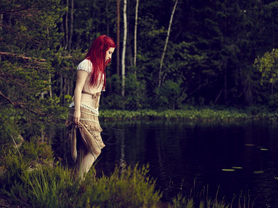 穿着裙子的迷人年轻女站在水线边背面湖身着洋装夏天时尚女孩图片