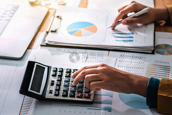花费桌子在金融和会计部门工作的商业妇女分析财务开支情况分析财政预算经济图片
