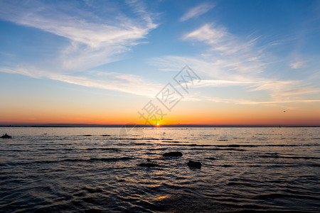 海浪爱沙尼亚塔林波罗的海上空日落时明亮的天空和水海滩太阳图片