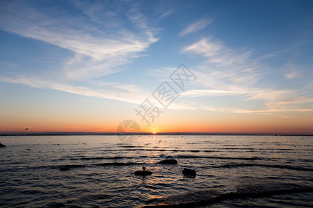 惊人的美丽云爱沙尼亚塔林波罗的海上空日落时明亮的天空和水图片