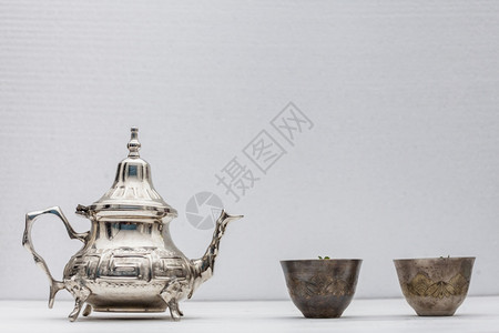 金属传统的草本植物阿拉伯茶杯和壶白桌图片